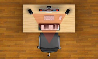 Home office setup featuring iLoud Micro speakers alongside a keyboard and computer